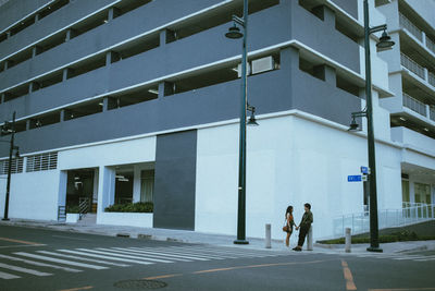 People walking on road amidst buildings in city