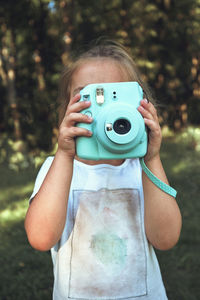 Portrait of girl holding camera