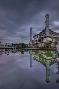 Reflection of building in lake against sky