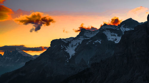 Scenic view of snowcapped mountains against sky during sunset