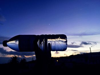 Close-up of silhouette hand against blue sky