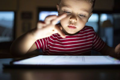 Cute boy using digital tablet at home