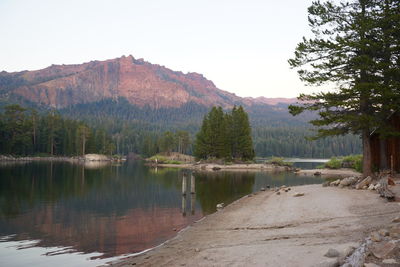 Scenic view of lake by mountain against clear sky