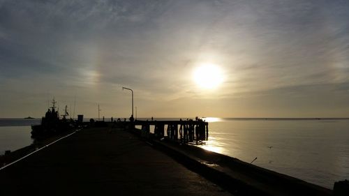 Pier on sea at sunset