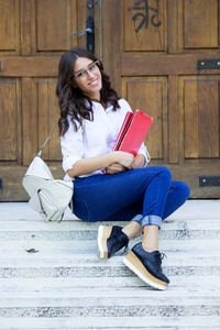 Young woman sitting on book