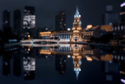 Reflection of illuminated buildings in city at night