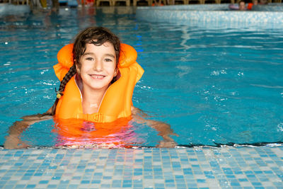 Portrait of young woman swimming in pool