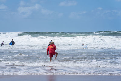 People on beach against sky