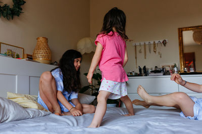 Little girls playing on parents bed at home