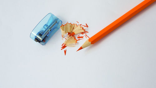 High angle view of colored pencils against white background