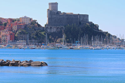 View of building by sea against clear sky