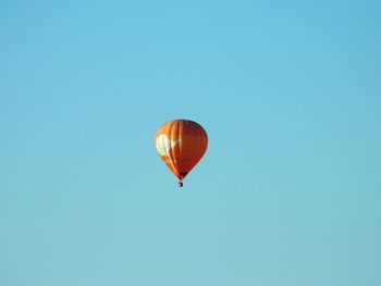 Low angle view of hot air balloon against clear blue sky