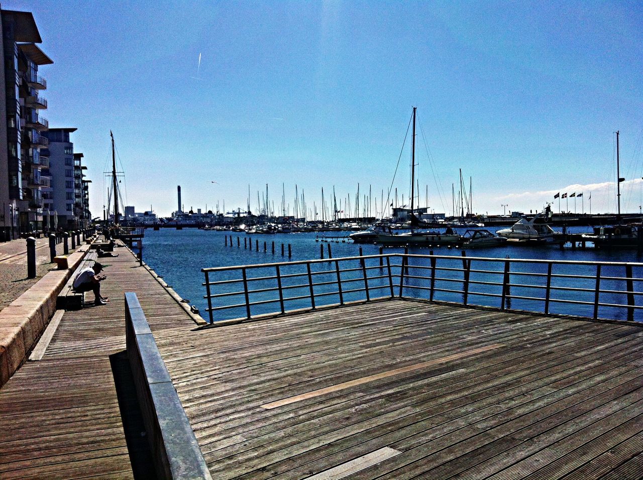 clear sky, water, sea, blue, transportation, built structure, pier, nautical vessel, harbor, moored, empty, sunlight, sky, absence, copy space, day, railing, architecture, outdoors, sand