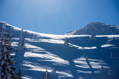 Snow covered mountain against blue sky