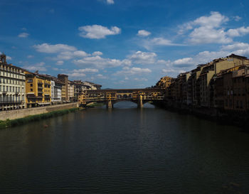 Bridge over river against buildings in city