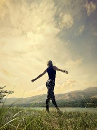 Full length of woman standing on field against sky