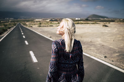 Rear view of woman standing on road