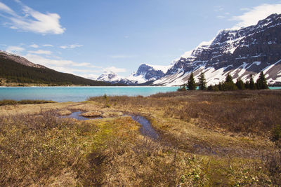 Scenic view of lake by mountains against sky