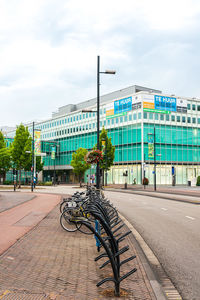 Bicycle parked on street against buildings in city