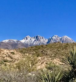 Scenic view of mountains against clear blue sky