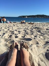 Low section of person on sand at beach