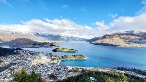 Aerial view of sea by mountain against sky