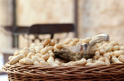 Wicker basket of raw organic peanuts in shell with metal scoop 