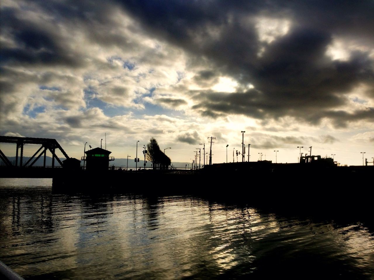 water, sky, cloud - sky, harbor, waterfront, cloudy, built structure, architecture, river, nautical vessel, cloud, transportation, reflection, sunset, commercial dock, crane - construction machinery, building exterior, silhouette, dusk, moored