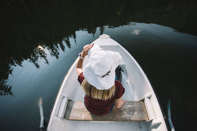 High angle view of woman sitting in boat on lake