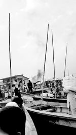 People on harbor by sea against sky