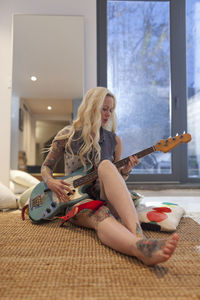 Beautiful young woman playing an electric guitar