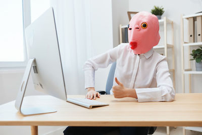 Portrait of young woman working at desk in office