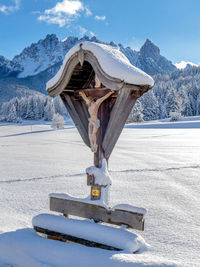 Built structure on snow covered field against sky