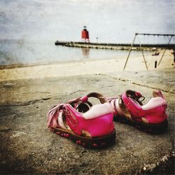 Close-up of pink container on beach