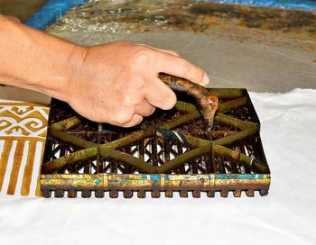 Cropped image of person working on barbecue grill