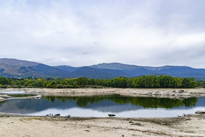 Scenic view of lake and mountains against sky