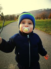 Portrait of boy standing in park during winter