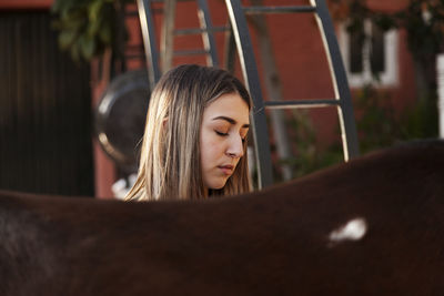 Portrait of young woman standing in stable