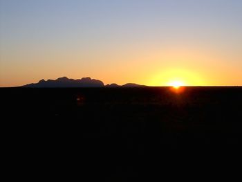 Scenic view of silhouette mountains against clear sky during sunset