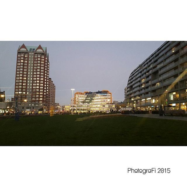 architecture, built structure, building exterior, transfer print, grass, clear sky, city, auto post production filter, sky, copy space, tower, outdoors, green color, building, day, modern, no people, mid distance, office building, lawn