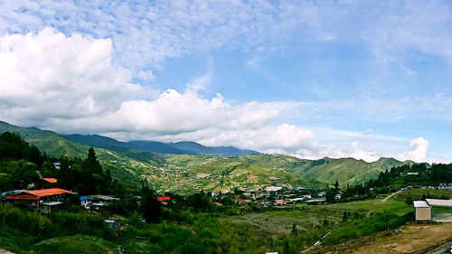 Scenic view of village against cloudy sky