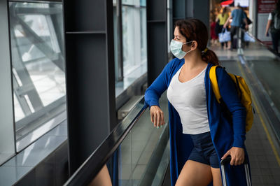 Full length of woman standing by railing