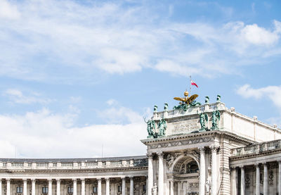 Low angle view of statues against cloudy sky