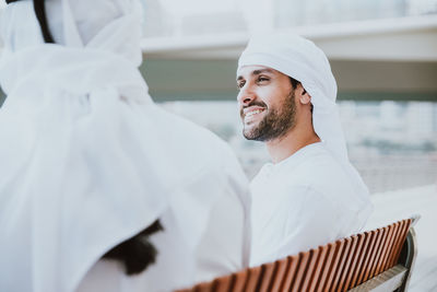 Smiling man having discussion with coworker against building