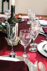 Close-up of wine bottles amidst glasses on table