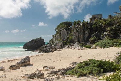 Scenic view of mayan ruins in tulum facing the turquoise caribbean sea.