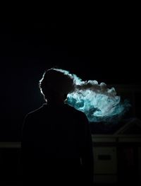 Silhouette man smoking at night