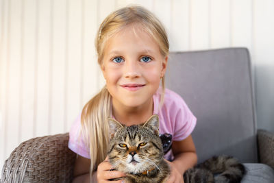 Portrait of cute girl with cat outdoors