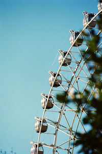 Low angle view of ferris wheel against clear blue sky