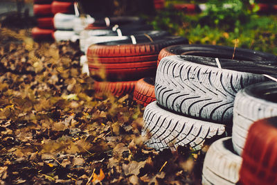 Close-up of tires by autumn leaves on field